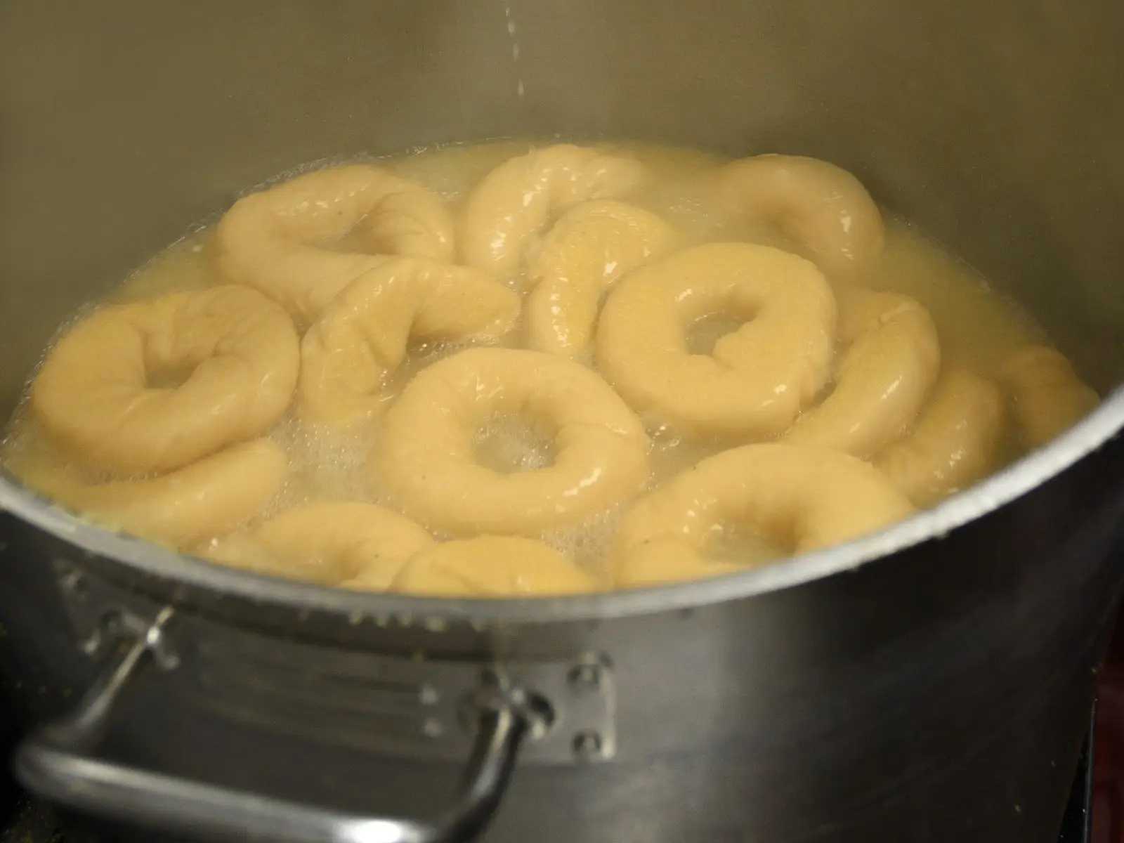 Bagels boiling in a big steel kettle